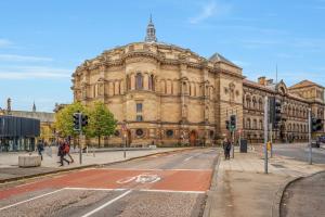 a large building on a street in front of a building at Spacious & Cosy Studio Flat in the Heart of Edinburgh City Centre in Edinburgh