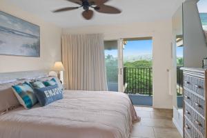 a bedroom with a bed with a ceiling fan and a balcony at Sapphire Oasis- Heavenly Ocean View and Resort in Kahana