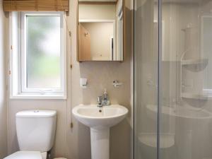 a bathroom with a toilet and a sink and a shower at Marlow Lodge in Hyssington