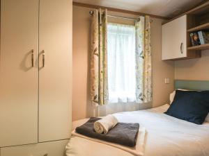 a small bedroom with a bed and a window at Marlow Lodge in Hyssington