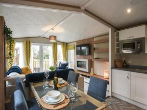 a kitchen and living room with a table and chairs at Marlow Lodge in Hyssington