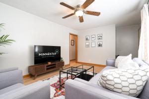 ein Wohnzimmer mit einem Sofa und einem TV in der Unterkunft Lake Nokomis Retreat in Minneapolis
