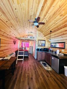 een houten huisje met een plafondventilator en een keuken bij Country Cabins Hotel in Chariton