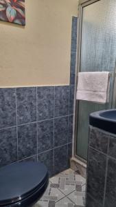 uma casa de banho com um WC azul e um chuveiro em AZURA HOTEL BOUTIQUE em Cobán