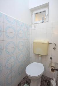 a bathroom with a white toilet and a window at Apartments by the sea Grebastica, Sibenik - 482 in Grebaštica