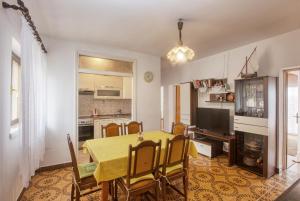 a kitchen and dining room with a yellow table and chairs at Apartments by the sea Grebastica, Sibenik - 482 in Grebaštica