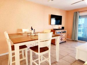 uma sala de jantar com uma mesa com cadeiras e uma televisão em Beachfront Condo In Paradise em Ocean City