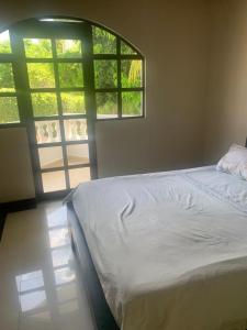 - un lit blanc dans une chambre avec fenêtre dans l'établissement Casa campestre Hacienda la estancia, en Melgar con piscina privada, à Melgar