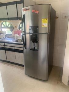 - un réfrigérateur en acier inoxydable dans la cuisine dans l'établissement Casa campestre Hacienda la estancia, en Melgar con piscina privada, à Melgar