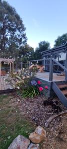 a wooden deck with a bench and some flowers at Wally's Edge 20acre Farm Stay in Rawson