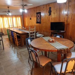 uma sala de jantar com uma mesa e cadeiras e uma televisão em Cabaña - Casa de campo La Tati em Ullún