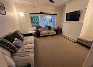 a living room with a couch and a flat screen tv at Cheerful 3 bedroom home in the centre of town in Shepparton