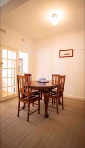 jadalnia ze stołem i 2 krzesłami w obiekcie Cheerful 3 bedroom home in the centre of town w mieście Shepparton