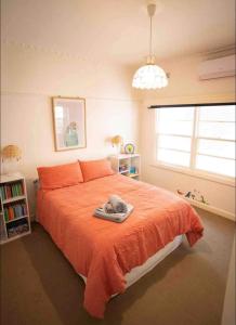 a bedroom with a large bed with an orange blanket at Cheerful 3 bedroom home in the centre of town in Shepparton