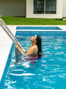 une femme est dans une piscine dans l'établissement HOTEL ISLA, à Isla Aguada
