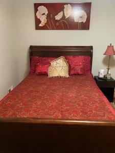 a bed with a red comforter and two pillows on it at Caribbean Comfort Zone in Chesterfield