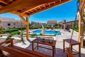 un patio avec une balançoire et une piscine dans l'établissement Family-friendly apartments with swimming pool Sveti Filip i Jakov, Biograd - 20861, à Sveti Filip i Jakov