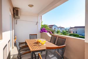 une table et des chaises en bois sur un balcon dans l'établissement Family-friendly apartments with swimming pool Sveti Filip i Jakov, Biograd - 20861, à Sveti Filip i Jakov