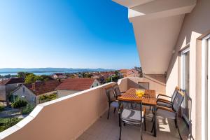 un balcon avec une table et des chaises et une vue dans l'établissement Family-friendly apartments with swimming pool Sveti Filip i Jakov, Biograd - 20861, à Sveti Filip i Jakov