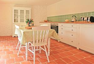 a kitchen with a table and chairs in a kitchen at Maison de LOlivier, Beautiful Townhouse with Private courtyard in Eymet
