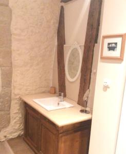 a bathroom with a sink and a mirror at Maison de LOlivier, Beautiful Townhouse with Private courtyard in Eymet +12 photos