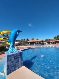 a dolphin statue in the middle of a pool at JL Temporadas - Quarto Portobello Park Hotel in Porto Seguro