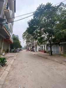 an empty street with a tree and buildings at Michi House Giang Văn Minh đối diện Bảo tàng HCM in Hanoi
