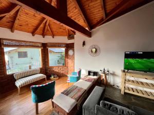 sala de estar con TV de pantalla plana y sofá en Casa en Bariloche con salida al lago en San Carlos de Bariloche