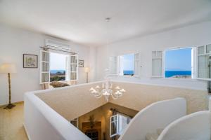 a living room with a fireplace and a chandelier at Oia Sunset Luxury Villa in Oia