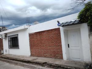 un edificio de ladrillo blanco y rojo con puerta blanca en Departamento Juana-Franch en Salta