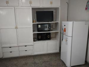 cocina con armarios blancos y nevera blanca en Departamento Juana-Franch en Salta