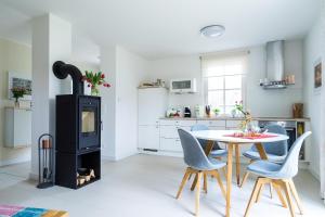 a living room with a stove and a table and chairs at Ferienhaus Greta in Glowe