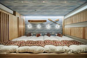 a large bed in a bedroom with a clock on the wall at Hotel TORACO konohana in Osaka