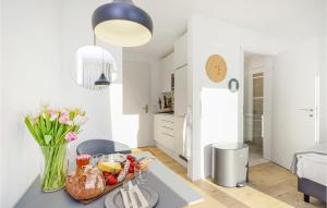 a kitchen with a tray of fruit and flowers on a counter at Pet Friendly Apartment in Lembruch +20 photos
