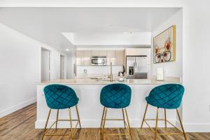 a kitchen with two blue chairs at a counter at Beachwalk Resort #3302 - PENTHOUSE IN THE SKY 3BDR and 3BA LUXURY CONDO DIRECT OCEAN VIEW in Hallandale Beach