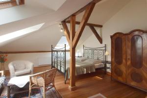 ein Schlafzimmer mit einem Bett und einem Stuhl in der Unterkunft Ferienwohnungen Villa Haniel Sophie in Dresden