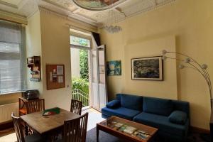 een woonkamer met een blauwe bank en een tafel bij Ferienwohnungen Villa Haniel Carl in Dresden