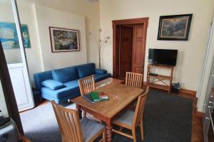 a living room with a table and a blue couch at Ferienwohnungen Villa Haniel Carl in Dresden