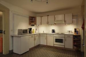 a kitchen with white cabinets and a microwave at Ferienwohnung Villa Haniel Oskar in Dresden