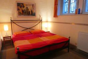 ドレスデンにあるFerienwohnung Villa Haniel Oskarのベッドルーム1室(赤と黄色の毛布付きのベッド1台付)