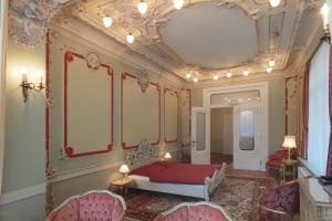 a bedroom with a red bed and a fancy ceiling at Ferienwohnungen Villa Haniel Hugo in Dresden