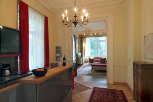 een woonkamer met een tafel en een kroonluchter bij Ferienwohnungen Villa Haniel Hugo in Dresden