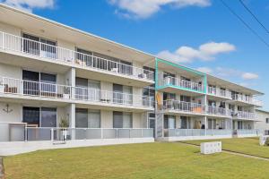 un edificio de apartamentos con césped delante en Longbeach Unit 12, en Gold Coast