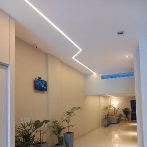 un pasillo con plantas y TV en la pared en Jade Barrio Sur A Estrenar by Citrino Aparts, en San Miguel de Tucumán