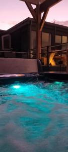 a swimming pool with blue water in front of a house at Wally's Edge 20acre Farm Stay in Rawson