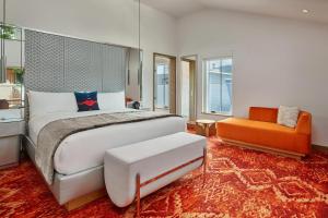 The Sky Residences at W Aspen في أسبين: غرفة نوم بسرير كبير وكرسي برتقالي