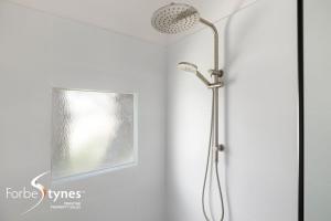 a shower with a shower head in a bathroom at Mosswood 1 in Thredbo