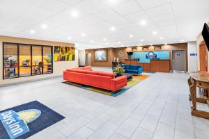 a lobby of a hospital with a red couch at Days Inn & Suites by Wyndham San Antonio near Frost Bank Center in San Antonio