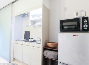 a kitchen with a microwave on top of a refrigerator at NEW! Studio Modern Unit in Shibuya Scramble! in Tokyo