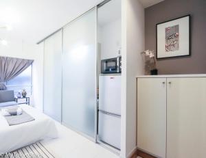 a bedroom with a large glass partition with a refrigerator at NEW! Studio Modern Unit in Shibuya Scramble! in Tokyo